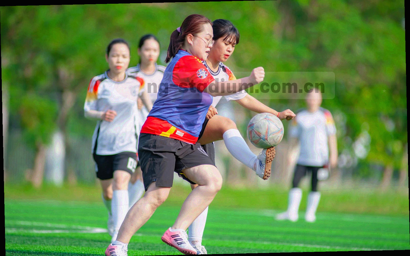 俯拍灯光下的球场草皮与看台结构，画面中无人物与队徽